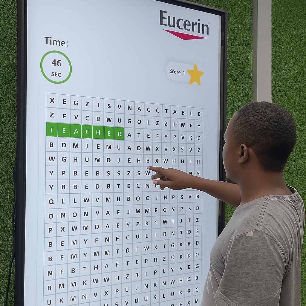 Guest playing interactive word search game at corporate event in Dubai, with branded screen, vibrant green backdrop