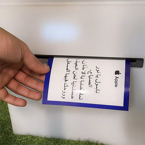 Young Emirati guest using AI Poem Generator kiosk in Dubai, creating personalized Arabic or English poem with instant printout and event branding