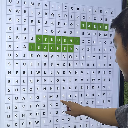 Guest playing interactive word search game at corporate event in Dubai, with branded screen, vibrant green backdrop