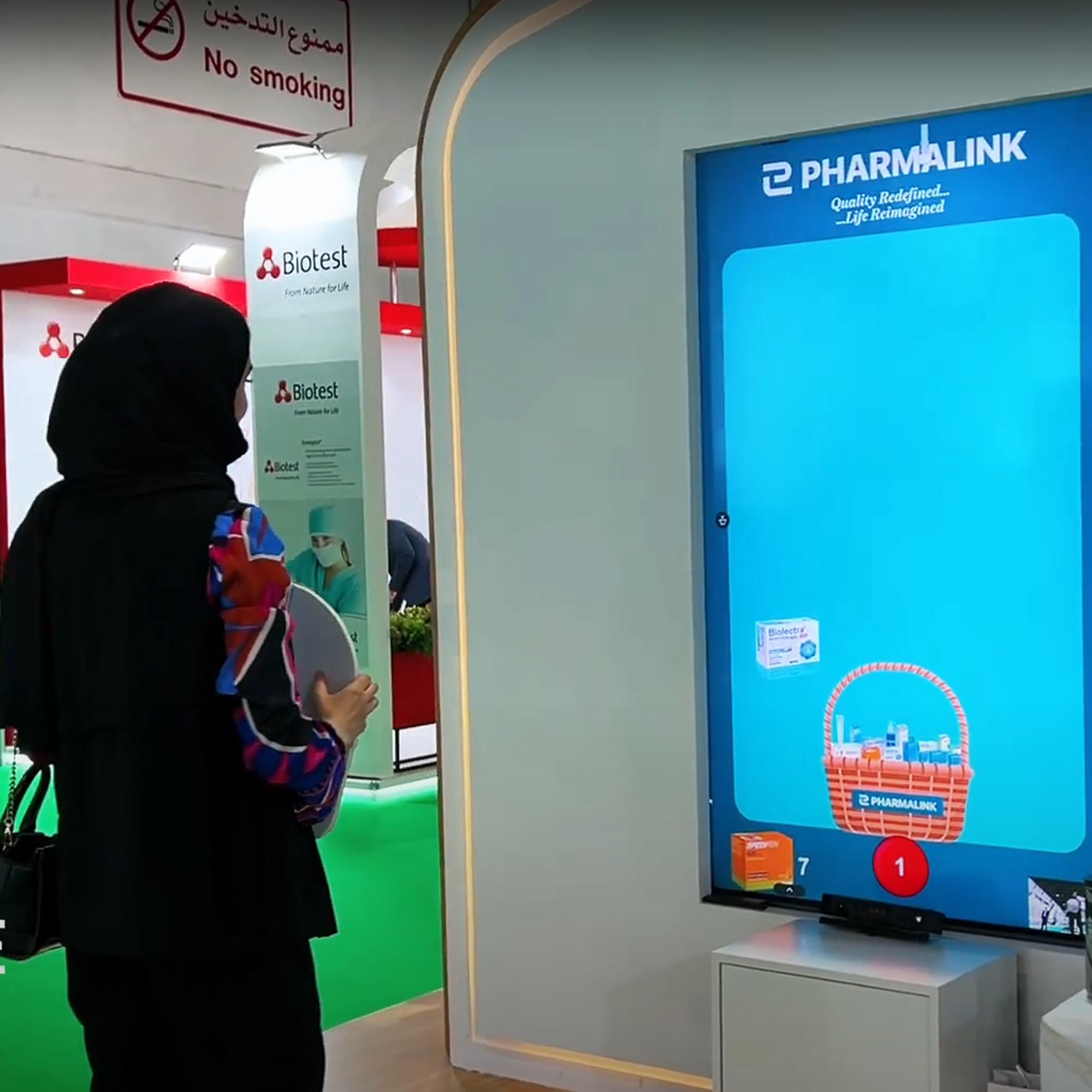 Player using body to slash branded items in a motion sensor game at exhibition in Dubai