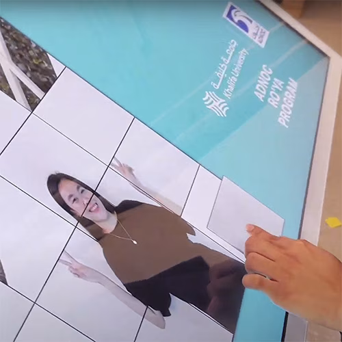 Player solving a shuffled photo puzzle of their face during an interactive event challenge.