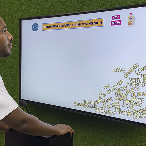 Arab woman using Sayit AI at a Dubai corporate event, speaking into a mic as 3D branded text appears on a large screen, showcasing interactive event technology rental