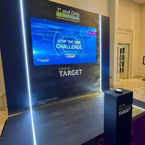 Guests playing Stop the Time interactive stopwatch game at a corporate event booth in Dubai, engaging with branded screen and trying to press the button at the perfect moment